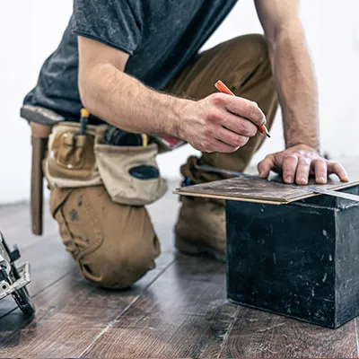 Homme coupant une lame de parquet