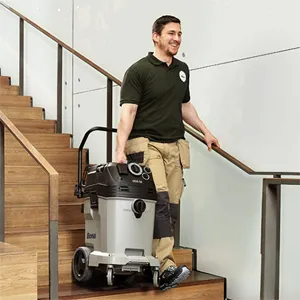 Un technicien en rénovation de parquet descend un escalier avec un aspirateur de la marque Bona