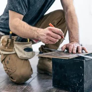 Homme coupant une lame de parquet