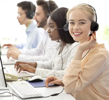 une hotline au travail, jeune fille souriante en premier plan